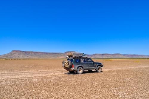 Car traveling on a dry lake bed - Australian Stock Image