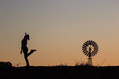 Carefree cowgirl plus windmill silhouette - Australian Stock Image