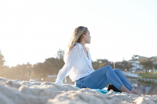 Carefree young blonde-haired woman at beach enjoying the sunshine - Australian Stock Image