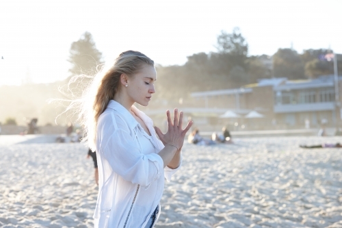 Carefree young blonde woman at beach enjoying the sunshine - Australian Stock Image