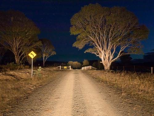 Cattle grid on a gravel road at night in car headlights - Australian Stock Image