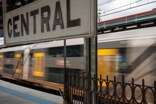 Central railway station sign with train passing the platform - Australian Stock Image