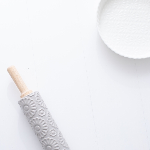 Ceramic pie dish and rolling pin on blank background - Australian Stock Image