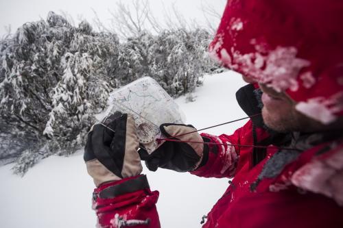 Checking the map whilst winter hiking - Australian Stock Image