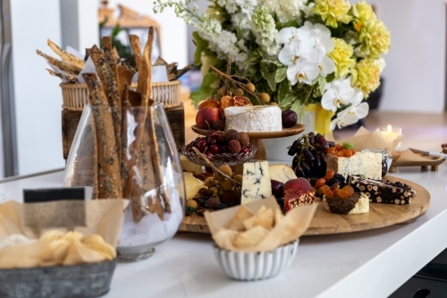 cheese board filled with cheeses and fruits - Australian Stock Image