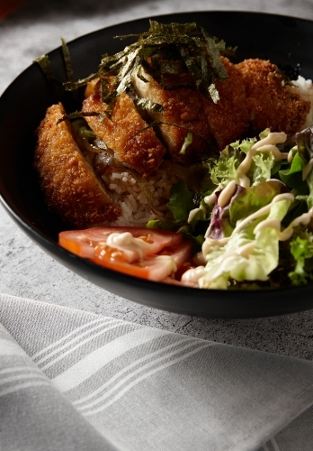 Chicken katsu on rice with salad - Australian Stock Image