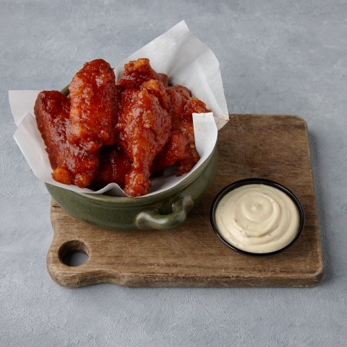 Chicken wings and sauce on table - Australian Stock Image