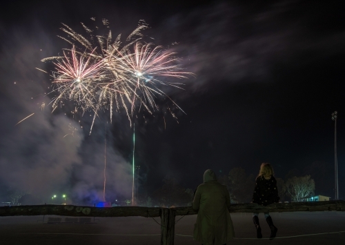 Child and adult watching firework display - Australian Stock Image