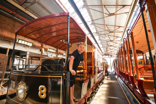 Child exploring vintage tram at historic museum - Australian Stock Image