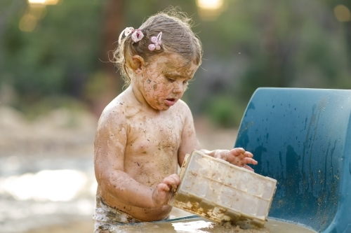 Child playing with mud - Australian Stock Image