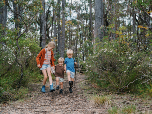 Children exploring Australian Bushland walking down trail together - Australian Stock Image