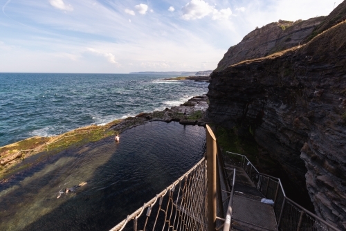 Children swimming in the Bogey Hole, historic man-made rock pool in Newcastle NSW - Australian Stock Image