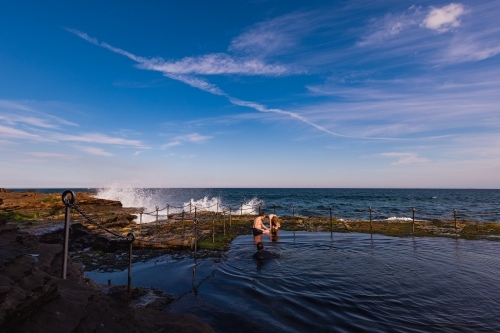 Children swimming in the Bogey Hole, historic man-made rock pool in Newcastle NSW - Australian Stock Image