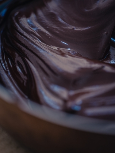 Chocolate icing mixture in bowl - Australian Stock Image