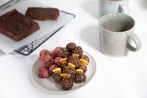 Chocolate protein balls on a white kitchen bench - Australian Stock Image