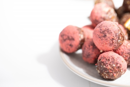 Chocolate protein balls on a white kitchen bench - Australian Stock Image