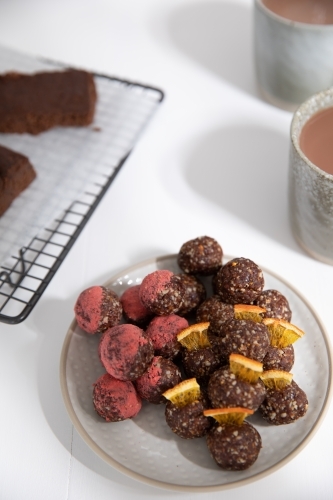 Chocolate protein balls on a white kitchen bench - Australian Stock Image