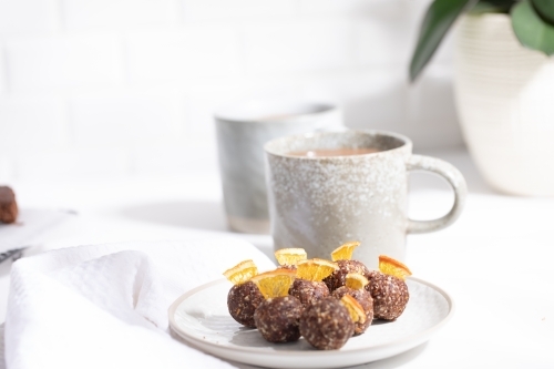 Chocolate protein balls on a white kitchen bench - Australian Stock Image