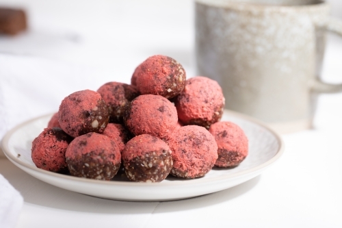 Chocolate protein balls on a white kitchen bench - Australian Stock Image