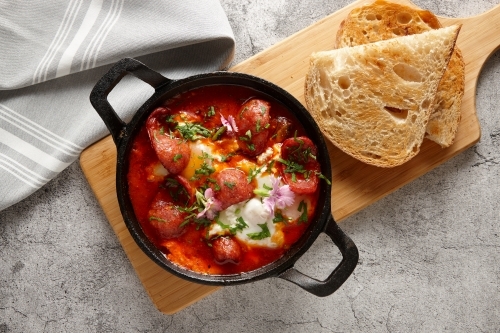 Chorizo dish in pan with toast - Australian Stock Image