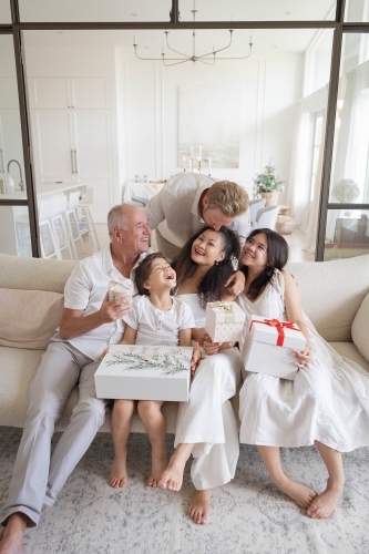 Christmas family photo on couch with presents - Australian Stock Image