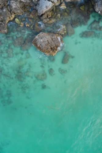 Cliff rocks in clear blue water at the Henderson limestone cliffs, near Perth, Western Australia - Australian Stock Image