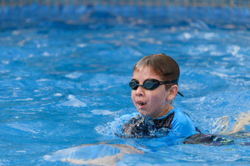 Close-up action portrait of a young swimmer while swimming breaststroke style in the swimming pool - Australian Stock Image