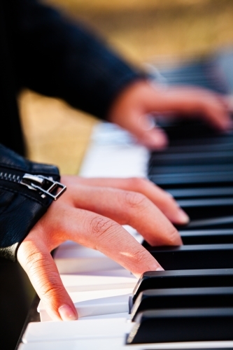 Close up detail of boy playing keyboard keys - Australian Stock Image