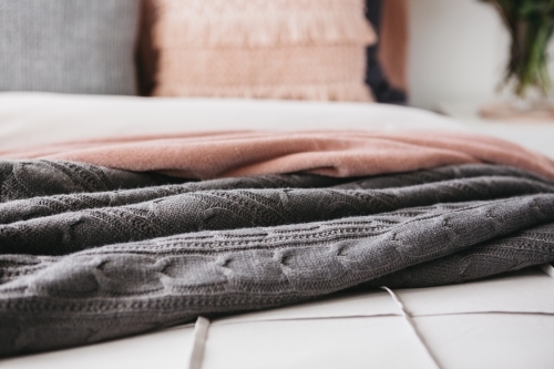 Close up detail of grey and pink throw rugs horizontal - Australian Stock Image