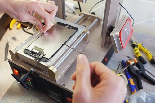 Close up hands repairing mobile screen, small business - Australian Stock Image