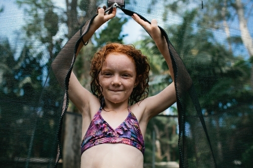 Close up of a girl standing on a trampoline in a bikini - Australian Stock Image