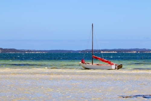 Close up of boat anchored in shallow water - Australian Stock Image