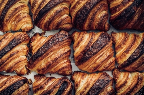 Close up of croissants arranged together on baking paper