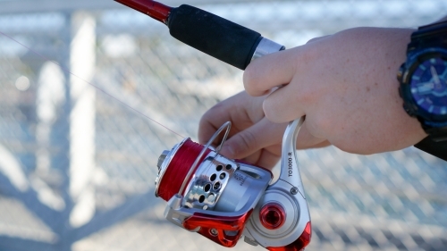 Close up of fishing reel in hand