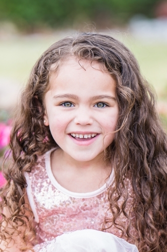 Close up of mixed race aboriginal caucasian girl smiling with curly hair - Australian Stock Image