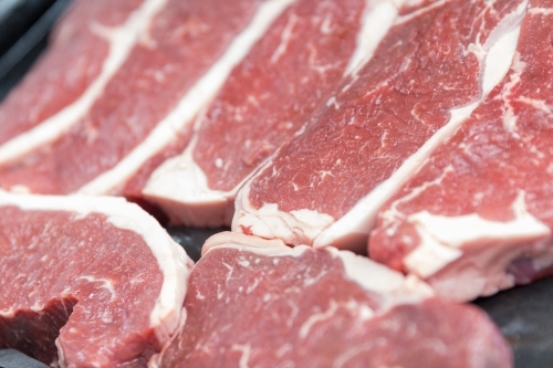 Close-up of raw steaks in butcher shop - Australian Stock Image