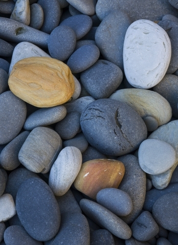 Close-up of rounded, multi-coloured stones on a cobble beach - Australian Stock Image