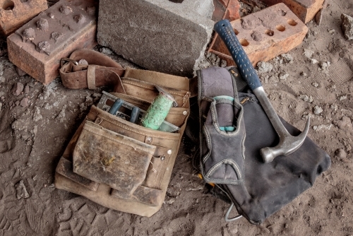 Close-up of tradesman's tool belt & tools on ground at building site - Australian Stock Image