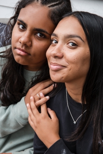 Close-up of two Aboriginal girls hugging - Australian Stock Image