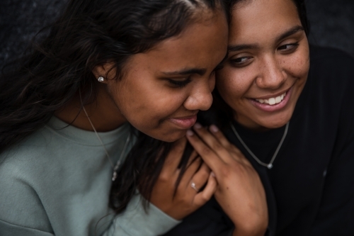 Close-up of two Aboriginal girls hugging - Australian Stock Image