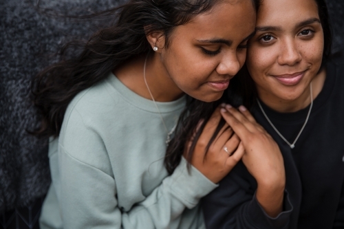Close-up of two Aboriginal girls hugging - Australian Stock Image