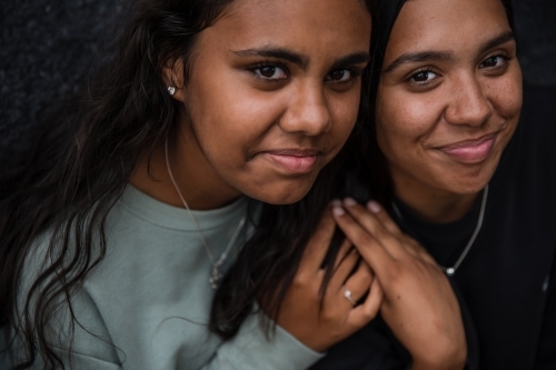 Close-up of two Aboriginal girls hugging - Australian Stock Image