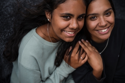 Close-up of two Aboriginal girls hugging - Australian Stock Image