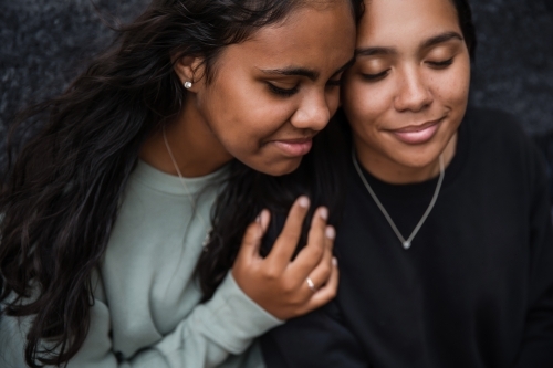 Close-up of two Aboriginal girls hugging - Australian Stock Image