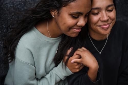 Close-up of two Aboriginal girls hugging - Australian Stock Image