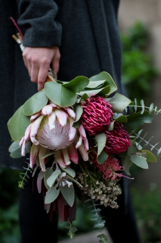 Close up of woman's hand holding a bouquet of native flowers - Australian Stock Image