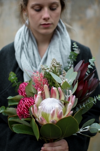 Close up of young woman holding a bouquet of native flowers