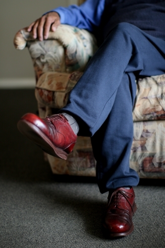 Close up on red leather dress shoe of an elderly Aboriginal man - Australian Stock Image