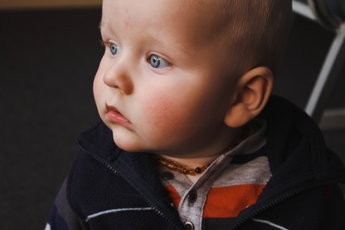 Close up portrait of blue eyed baby boy in soft window light - Australian Stock Image