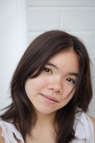 Close-up portrait of teenage girl making eye contact with camera - Australian Stock Image